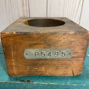 以下が含まれることがあります： 円形の切り抜きと「P5495」と書かれた金属タグが付いた木製の箱です。