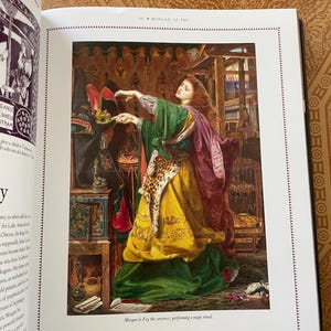 K&ouml;nnte beinhalten: Detaillierte Malerei von Morgan le Fay, der Zauberin, die ein magisches Ritual durchf&uuml;hrt. Sie tr&auml;gt ein gr&uuml;nes und gelbes Kleid mit einem Schal mit Leopardenmuster. Das Bild stammt aus einem Buch mit dem Text "Morgan le Fay die Zauberin, die ein magisches Ritual durchf&uuml;hrt."
