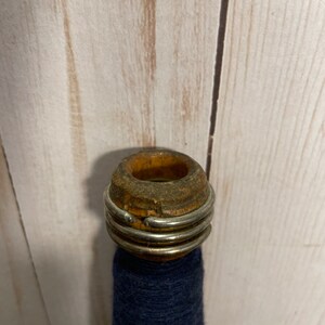 Peut inclure: Une bobine en bois avec un anneau m&eacute;tallique autour du haut, tenant un fil bleu fonc&eacute;.