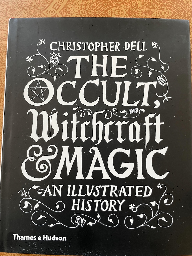 K&ouml;nnte beinhalten: Ein schwarzer Buchumschlag mit wei&szlig;em Text und Verzierungen. Der Titel lautet "The Occult, Witchcraft & Magic" von Christopher Dell, mit dem Untertitel "An Illustrated History". Herausgegeben von Thames & Hudson.