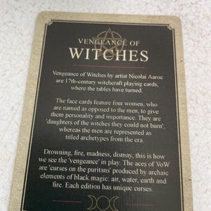 May include: A playing card from the "Vengeance of Witches" deck. The card has a dark background with the title "VENGEANCE OF WITCHES" in large, bold letters. The card's text describes the deck's theme of 17th-century witchcraft.