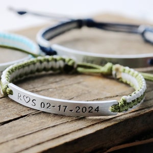 May include: A green and white braided bracelet with a silver metal tag engraved with "R&hearts;S 02-17-2024".