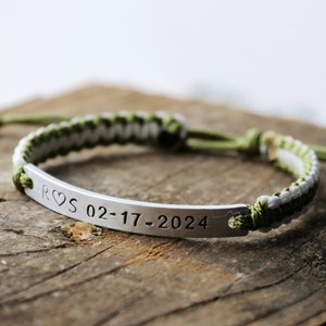 May include: A green and white braided cord bracelet with a silver metal bar engraved with "R&hearts;S 02-17-2024".