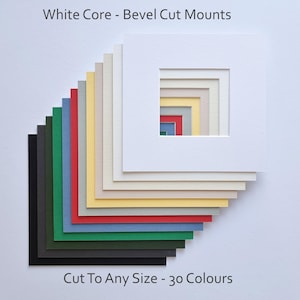 May include: A stack of 30 different coloured bevel cut mounting boards. The boards are arranged in a graduated pattern, with the largest board at the bottom and the smallest board at the top. The boards are all white core, and the text "White Core - Bevel Cut Mounts" is printed at the top of the image. The text "Cut To Any Size - 30 Colours" is printed at the bottom of the image.