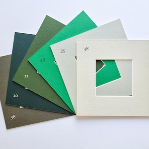 Puede incluir: Un abanico de seis paspart&uacute;s cuadrados de papel en varios tonos de verde y gris. Los paspart&uacute;s est&aacute;n etiquetados con los n&uacute;meros 36, 10, 11, 28, 35 y 38. Cada uno presenta un recorte cuadrado central que revela los colores de las capas.