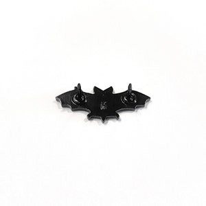 May include: Black metal bat pin with a star design on the back. The pin has two metal posts on the back for attaching to clothing.