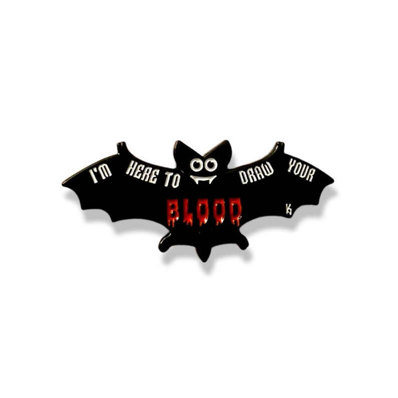 May include: Black enamel pin shaped like a bat with the text "I'm here to draw your blood" in white lettering. The bat has red dripping blood with a smiling face.