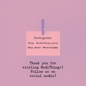 Puede incluir: Una nota rosa con el texto "Instagram: Shop: @medithings_gram Shop owner: @katerinadpm Thank you for visiting MediThings! Follow us on social media!" est&aacute; colgada de una cuerda con una pinza de ropa azul.