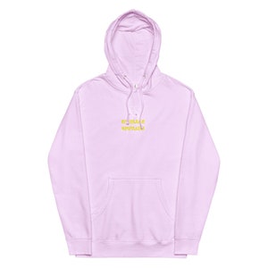 May include: A light purple hoodie with a white outline of a bear and the text "Embrace Empathy" in yellow.