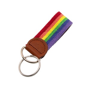 May include: A rainbow-colored key chain with a brown leather loop and two silver key rings.