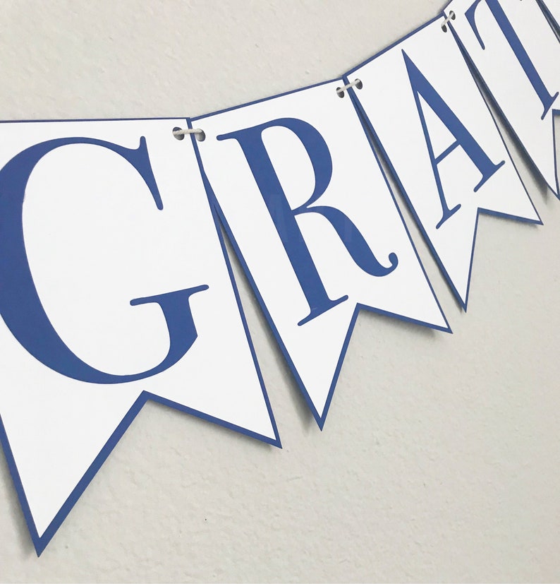K&ouml;nnte beinhalten: Ein wei&szlig;es Banner mit blauen Buchstaben, die "GRAD" in einer einfachen, klobigen Schriftart buchstabieren.