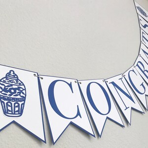 K&ouml;nnte beinhalten: Ein wei&szlig;-blaues Banner mit dem Wort "CONGRATS" in blauen Buchstaben. Das Banner hat auf der linken Seite ein blaues und wei&szlig;es chinesisches Porzellanmuster.