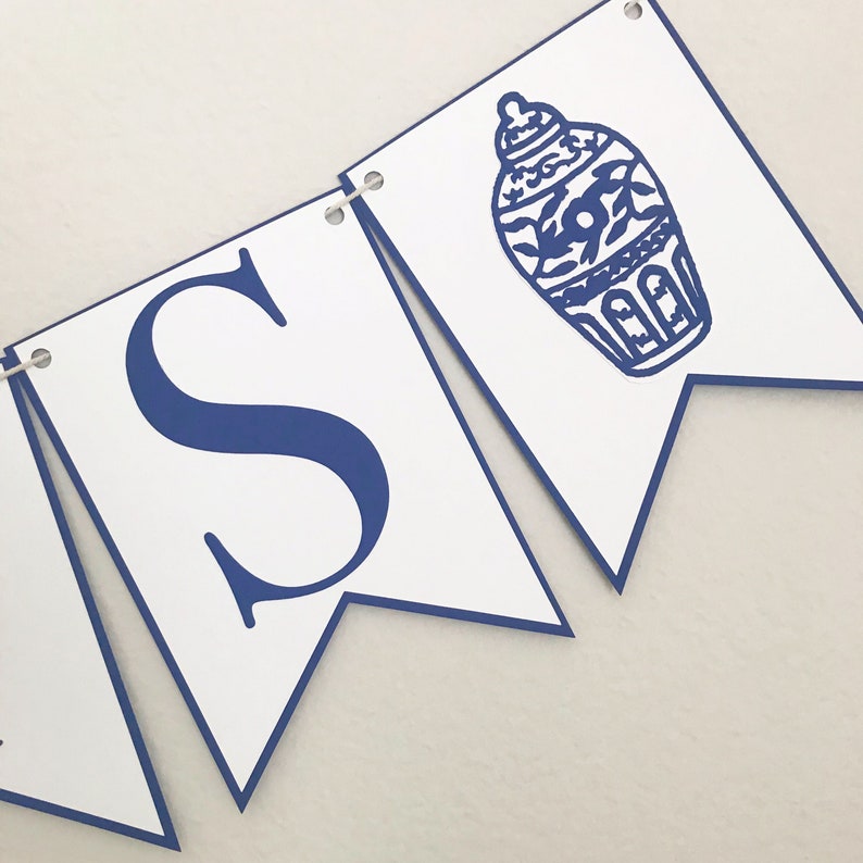 K&ouml;nnte beinhalten: Ein wei&szlig;es Banner mit blauem Besatz und blauer Beschriftung, die "S" lautet, und einer blauen und wei&szlig;en Illustration einer chinesischen Ingwervase.