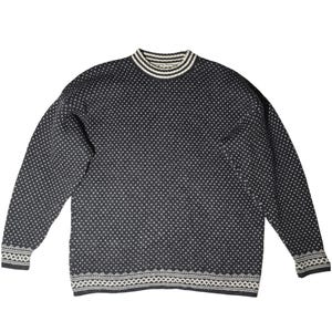 May include: A dark gray sweater with a white dotted pattern. The sweater has a mock neck and white stripes at the collar. The cuffs and hem have a white geometric design. A cozy, warm knitwear garment.