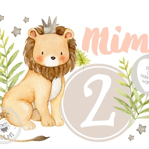 May include: A watercolour illustration of a lion wearing a crown, sitting on a light brown background with a large number 2. The lion is surrounded by green leaves and small grey stars. The text "mimi" is written in pink above the number 2. The text "Bugebild DIN A5 oder DIN A4 wahlbar" is written in a white heart on a grey background.