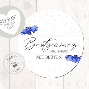 Op de afbeelding: Ronde witte sticker met de Duitse tekst "Brotgewürz mal anders mit Blüten" in zwart schrift, met blauwe bloemaccenten en kleine grijze stippen. Een hartvormige sticker leest "Sticker 12 Stück 6cm".