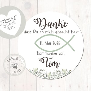Può includere: Adesivo rotondo bianco con la scritta "Danke" e "11. Mai 2025". Presenta un simbolo di pesce verde e foglie decorative. Include un adesivo più piccolo a forma di cuore con testo. L'adesivo è per una comunione.