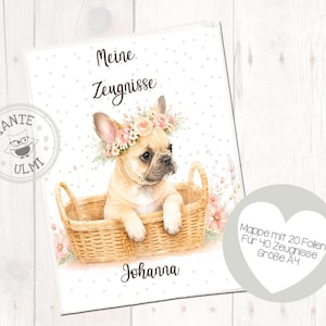 Peut inclure: Un porte-document A4 blanc avec une illustration aquarelle d'un bouledogue français fauve portant une couronne de fleurs, assis dans un panier en osier. Le texte indique Meine Zeugnisse, Johanna, et Mappe mit 20 Folien Für 40 Zeugnisse Größe A4.