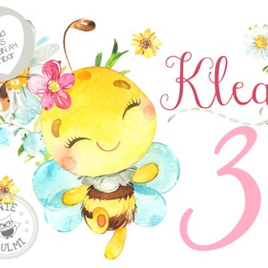 Può includere: Un'illustrazione ad acquerello di un'ape carina con un fiore rosa sulla testa. L'ape sta volando con le ali spiegate. Lo sfondo è bianco con un numero 3 rosa e il nome Kilea scritto in corsivo.