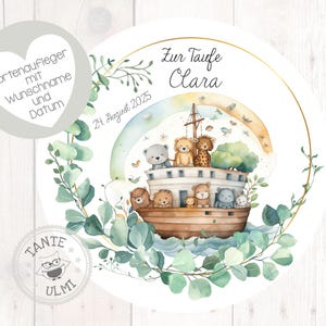 Könnte beinhalten: Ein runder Tortenaufleger im Aquarellstil mit einer Arche voller Tierfiguren, einem Regenbogen und dem Text "Zur Taufe Clara" und "21 August 2025". Das Design wird von grünem Laub umrahmt und enthält zusätzlichen Text auf Deutsch.