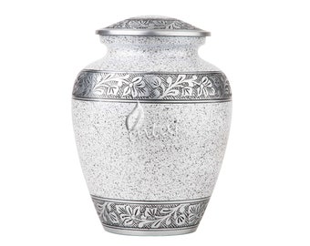 May include: A white urn with silver floral designs. The urn has a textured surface and a lid.