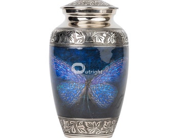 May include: A silver metal urn with a blue butterfly design. The urn has a silver lid and a floral design around the bottom.