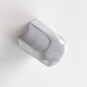May include: A white concrete knob with a textured surface and a rounded shape.