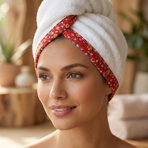 Puede incluir: Una toalla de pelo de felpa blanca con un borde rojo y un estampado floral colorido. La toalla est&aacute; asegurada en un estilo de turbante retorcido alrededor de la cabeza. El texto Style - 8 es visible en la parte inferior.