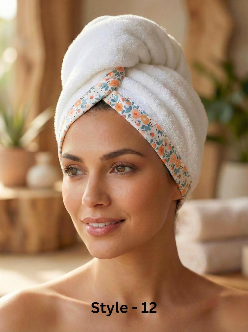 Puede incluir: Una toalla para el cabello de color blanco con un borde floral de flores naranjas y azules. La tela tiene una textura suave y afelpada, envuelta firmemente alrededor de la cabeza. El texto "Style - 12" aparece impreso en negro abajo.