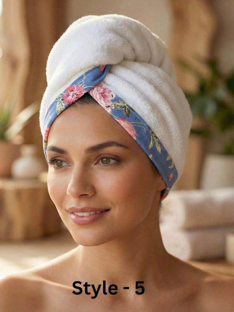 Puede incluir: Una toalla de pelo blanca de felpa con un borde azul con un estampado floral rosa y verde. La toalla est&aacute; retorcida y asegurada en la parte delantera, mostrando una textura suave y absorbente. El texto "Style - 5" aparece en la parte inferior.