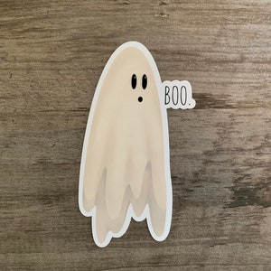 May include: A white ghost with black eyes and a surprised expression. The ghost is saying "BOO."