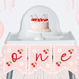 Peut inclure: Bannière de chaise haute rose et blanche avec le mot "one" en écriture rouge. La bannière a un motif à carreaux et des cerises et des marguerites. Un ballon rose et un gâteau blanc avec des cerises sur le dessus sont en arrière-plan.