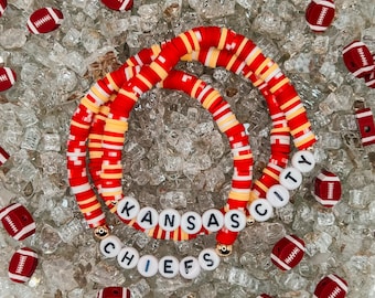 May include: Red, white, and yellow beaded bracelets with the words "Kansas City Chiefs" spelled out in white letters.