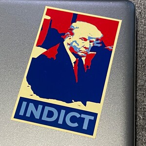 May include: A red, white, and blue political poster with a man's face and the word "INDICT" in large, blue letters.