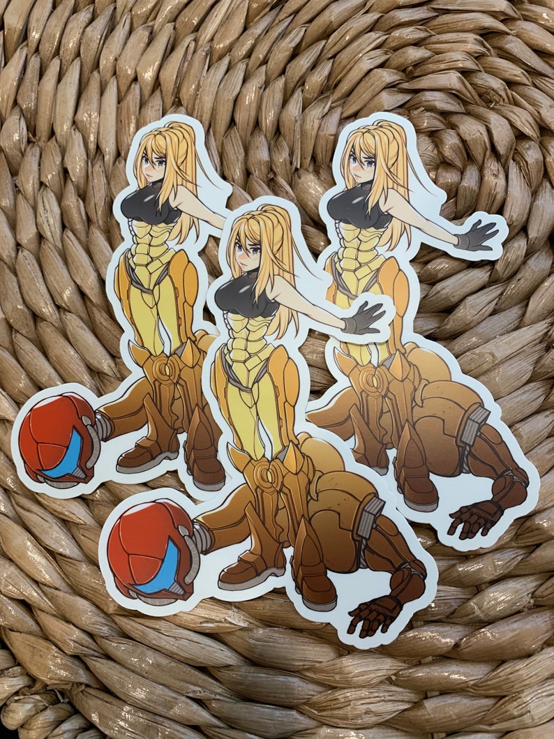 May include: Three stickers featuring a yellow-suited female character with blonde hair and a black top. The character is in a fighting pose. The stickers are on a woven background.