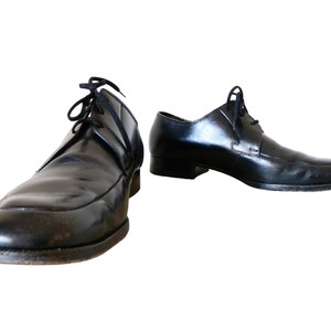 May include: A pair of black leather lace-up shoes with a pointed toe.