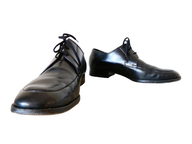 May include: A pair of black leather lace-up shoes with a pointed toe.