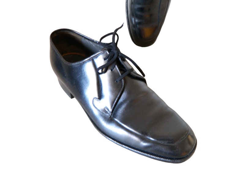 May include: A pair of black leather lace-up shoes with a pointed toe.
