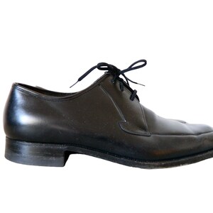 May include: A pair of black leather lace-up shoes with a rounded toe.