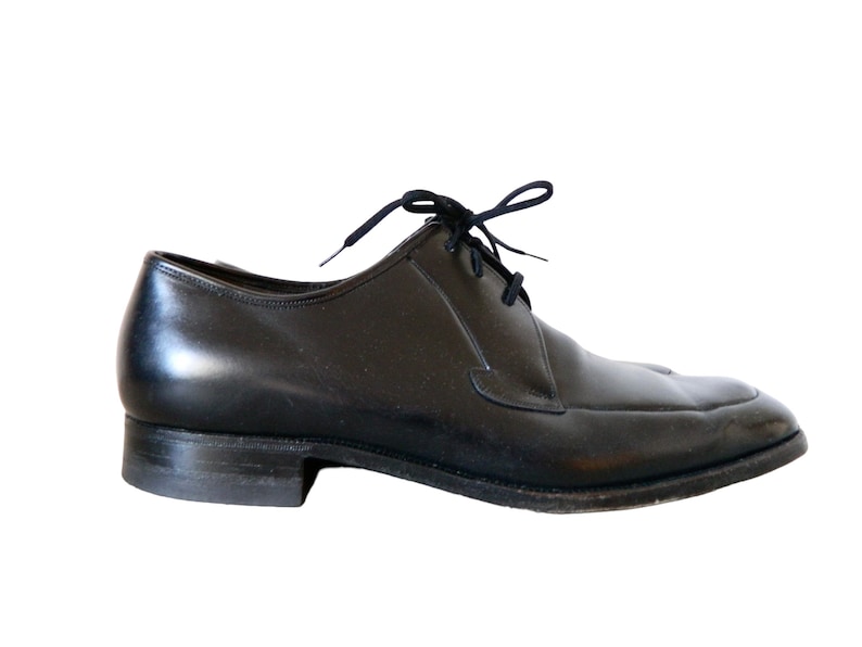 May include: A pair of black leather lace-up shoes with a rounded toe.