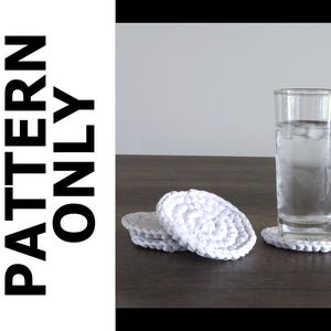 Puede incluir: Una pila de tres posavasos redondos de ganchillo blanco y un posavasos individual de ganchillo blanco que sostiene un vaso transparente lleno de agua y cubitos de hielo. El texto PATTERN ONLY está impreso en letras mayúsculas negras.