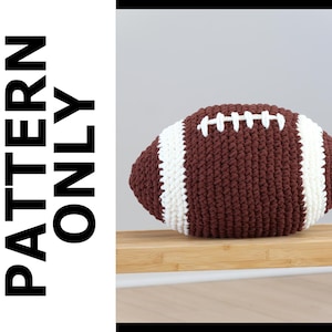May include: A handmade, brown and white crochet football. The football has white stripes and white stitching. The text "PATTERN ONLY" is printed vertically on the left side of the image.