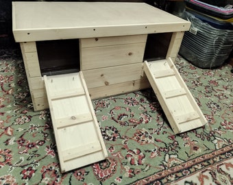 May include: A wooden pet house with two ramps. The house is made of light wood and has a natural finish. The ramps are also made of wood and have a light brown finish.