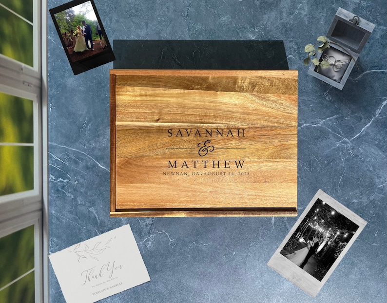 May include: A wooden chopping board with a personalised inscription for a wedding. The inscription reads "Savannah & Matthew, Newnan, GA, August 14, 2023".