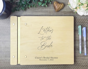 May include: A wooden guest book with the text "Letters to the Bride" and "Claire's Bridal Shower November 7, 2022".