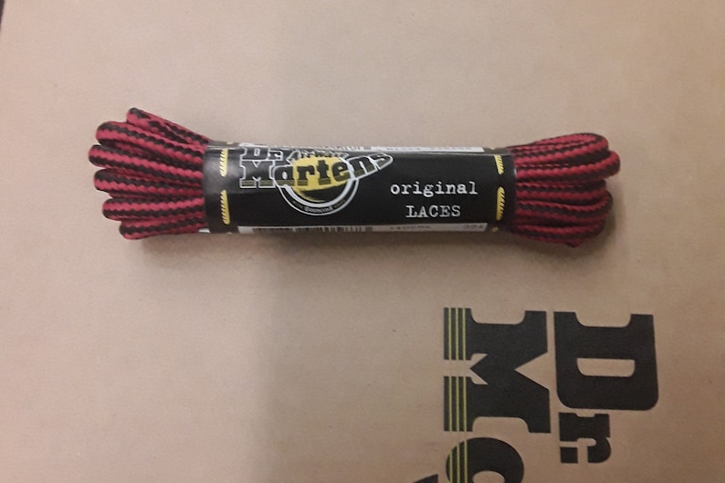 May include: A package of black and red striped shoelaces with the text "Dr. Martens original laces" on the label.