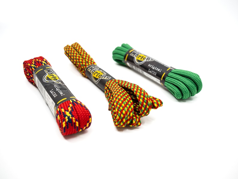 May include: Three pairs of Dr. Martens shoelaces in different colors and patterns. The laces are red and yellow, green and yellow, and green. Each pair has a Dr. Martens label with the text "original laces".