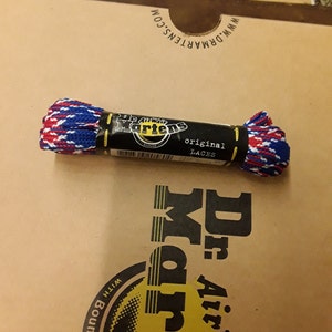 May include: A pair of red, white, and blue shoelaces in a plastic package labeled "Dr. Martens original laces".