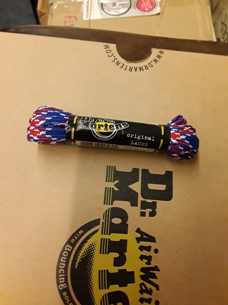May include: A pair of red, white, and blue shoelaces in a plastic package labeled "Dr. Martens original laces".