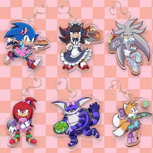 May include: Six acrylic keychains featuring Sonic the Hedgehog characters dressed in maid outfits. The characters include Sonic, Shadow, Silver, Knuckles, Big the Cat, and Tails, each holding a serving tray or food item with heart-shaped metal clasps.